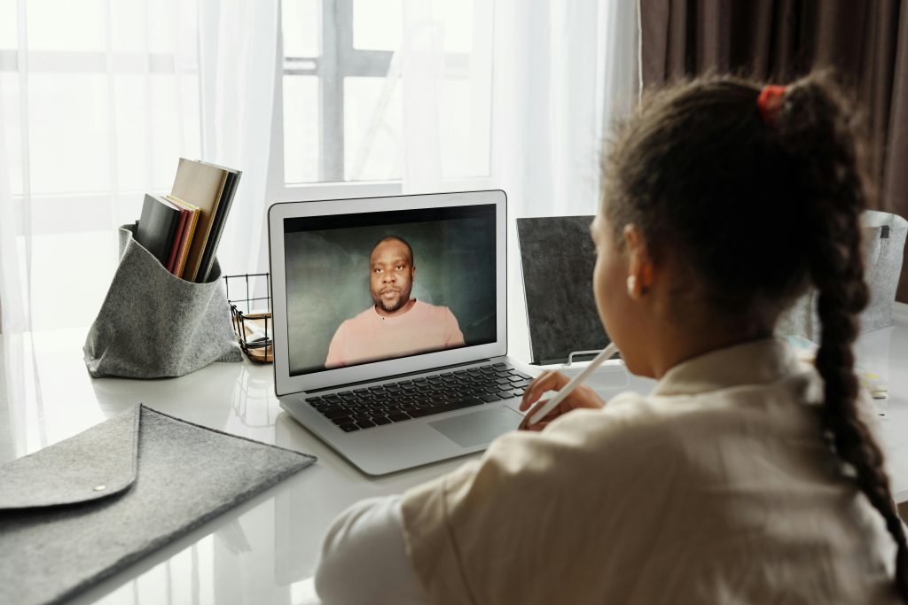 Child attending an online lesson at home via laptop. Remote education.